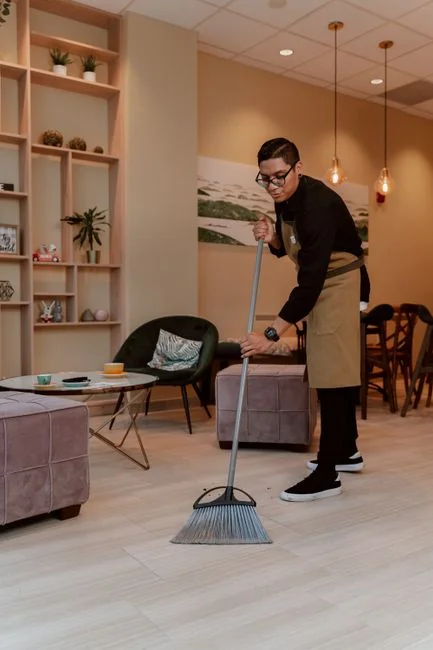 Un homme adulte nettoyant une vitre en intérieur, mettant l’accent sur les tâches ménagères et la propreté.